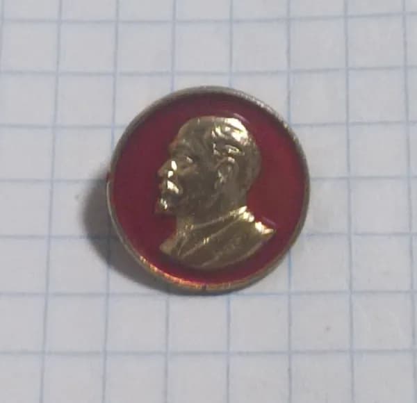 Значок с профилем Ленина на красном фоне