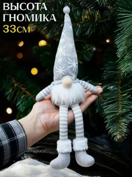 Рождественское украшение с гирляндами Рудольф подвешивает за ногу куклу гоблина